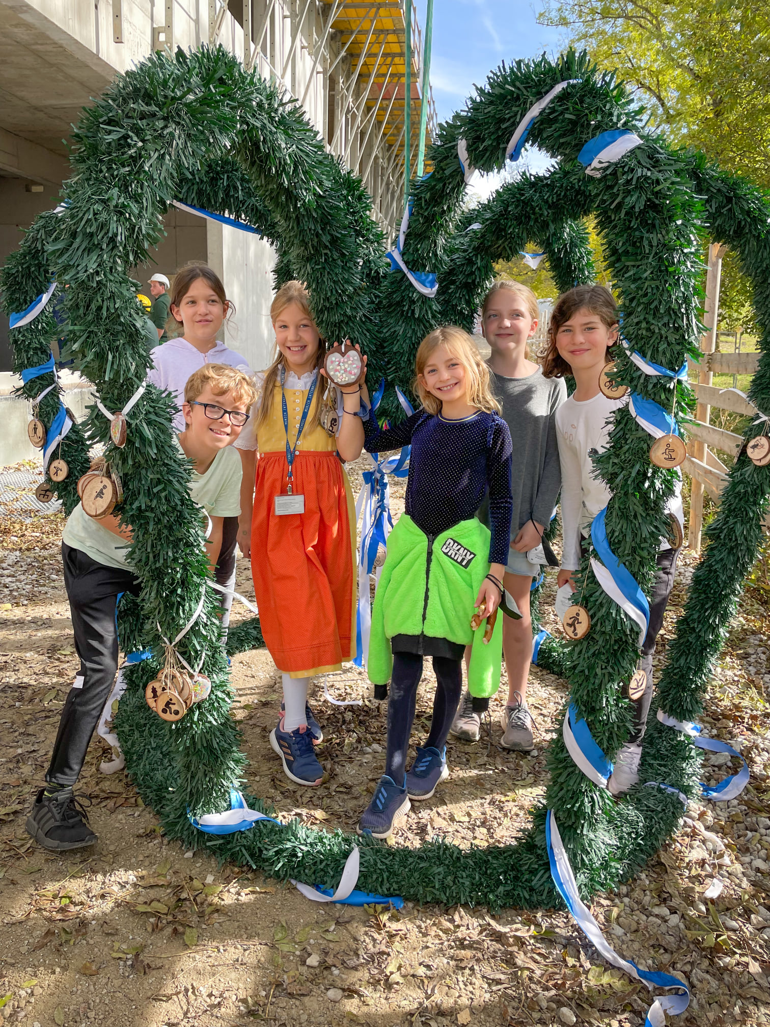 Foto von Schülerinnen und Schüler der Munich International School die den Richtkranz schmücken. 