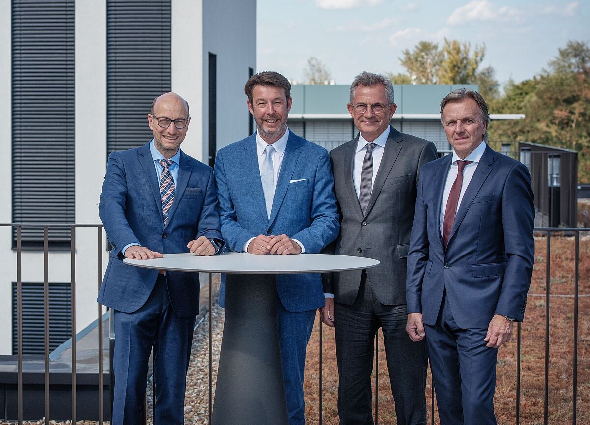 Foto von vier Personen, die an einem Stehtisch stehen