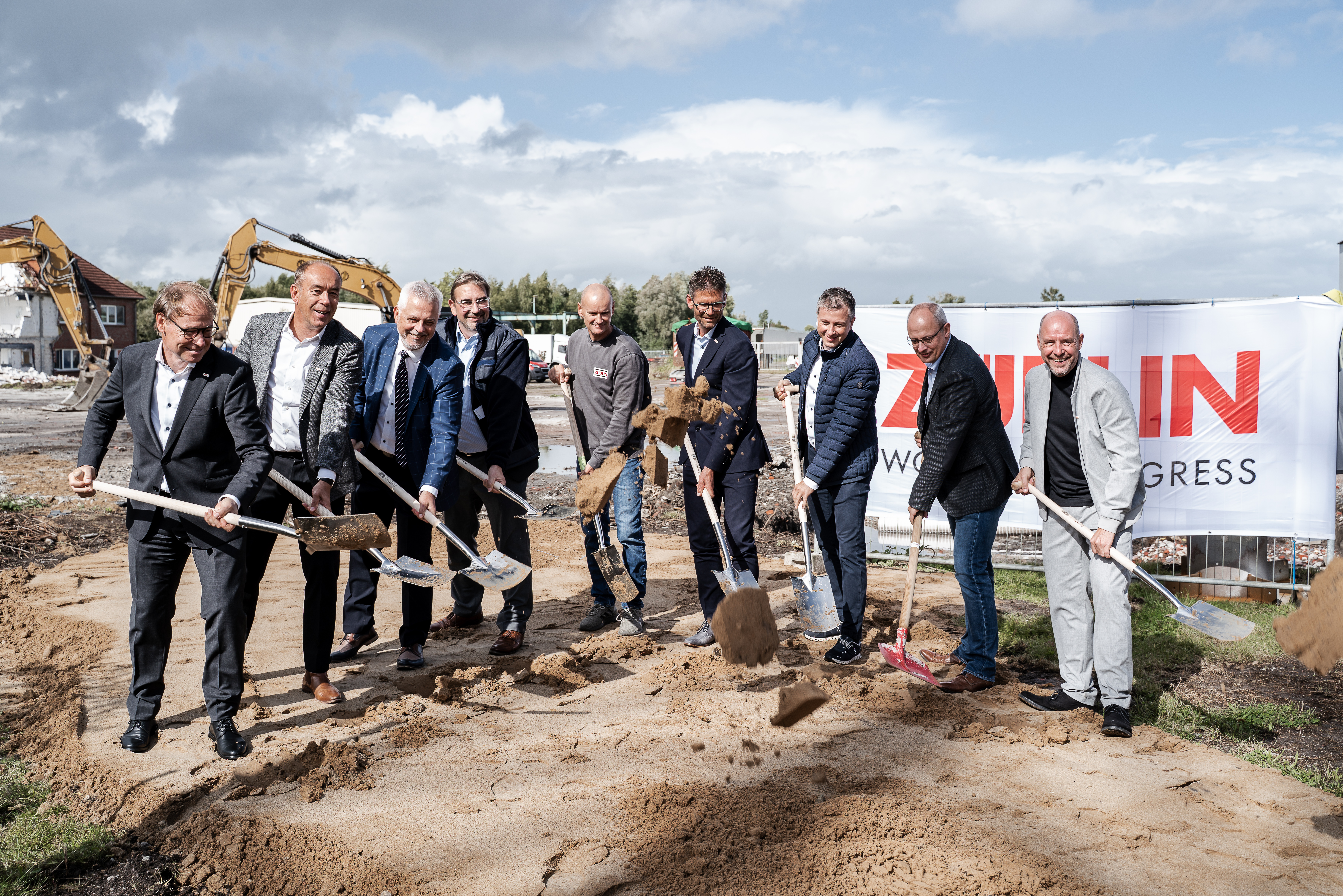 Das Bild zeigt Personen beim Spatenstich mit Schaufeln.
