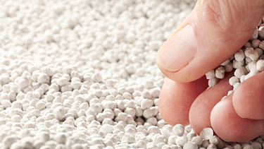 Photo of Polyhalite fertilizer and a hand