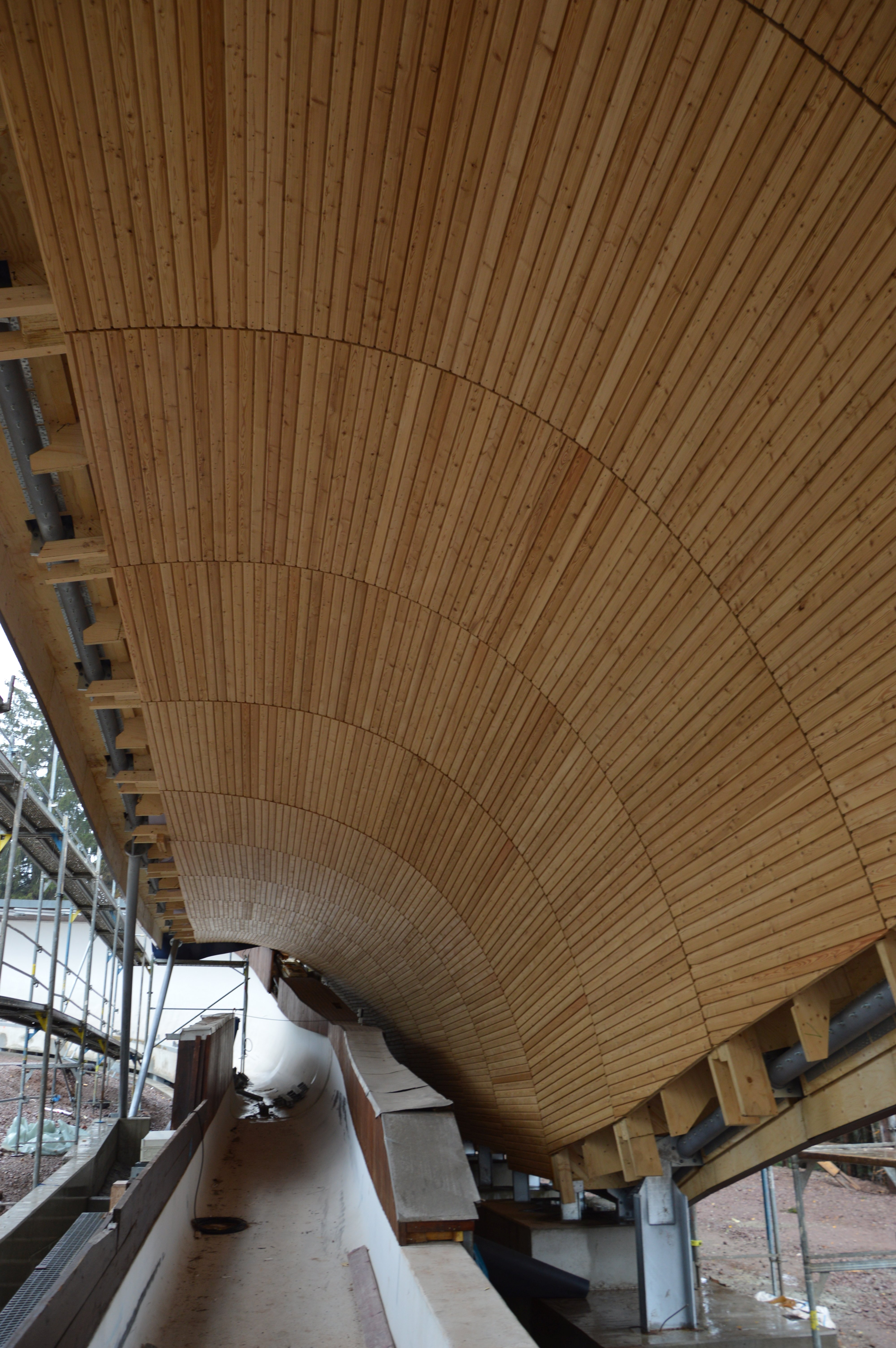 Foto von der Innenansicht einer Rennschlittenbahn mit Holzüberdachung.       