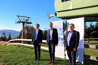 Foto von frei Männer in Anzug vor einer Seilbahn.  