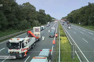 Das Bild zeigt zwei dreispurige Autobahnauschnitte, links mit mehreren Fahrzeugen, rechts ohne Fahrzeuge