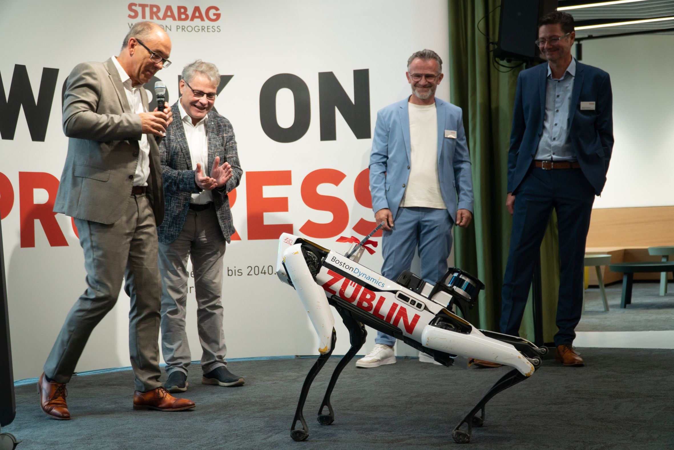 Foto von mehreren Personen, die einen Roboterhund in Aktion zuschauen. 