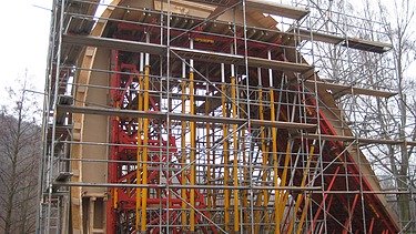  Foto von einem Bogen um den ein Gerüst gebaut ist.