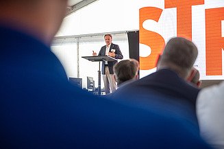 Mann auf einer Bühne spricht