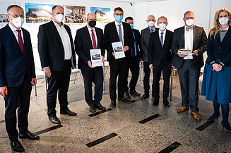 Photo of several people standing wearing corona masks
