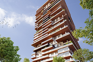 Foto zeigt einen Wohnbauturm mit Bäumen links und rechts