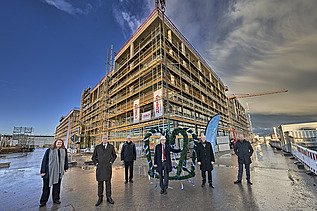 Foto von mehreren Personen die vorm Richtkranz stehen über dem LabCampus am Flughafen München.