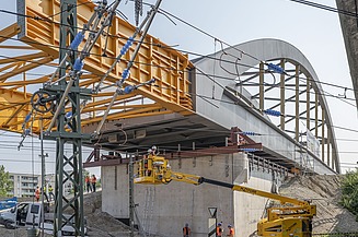 Foto vom Bau einer Brücke über Schienen. 