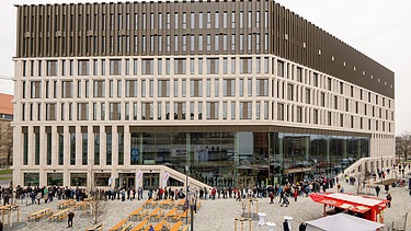 Bild eines neuen Gebäudes mit einer Glasfront vorne rechts