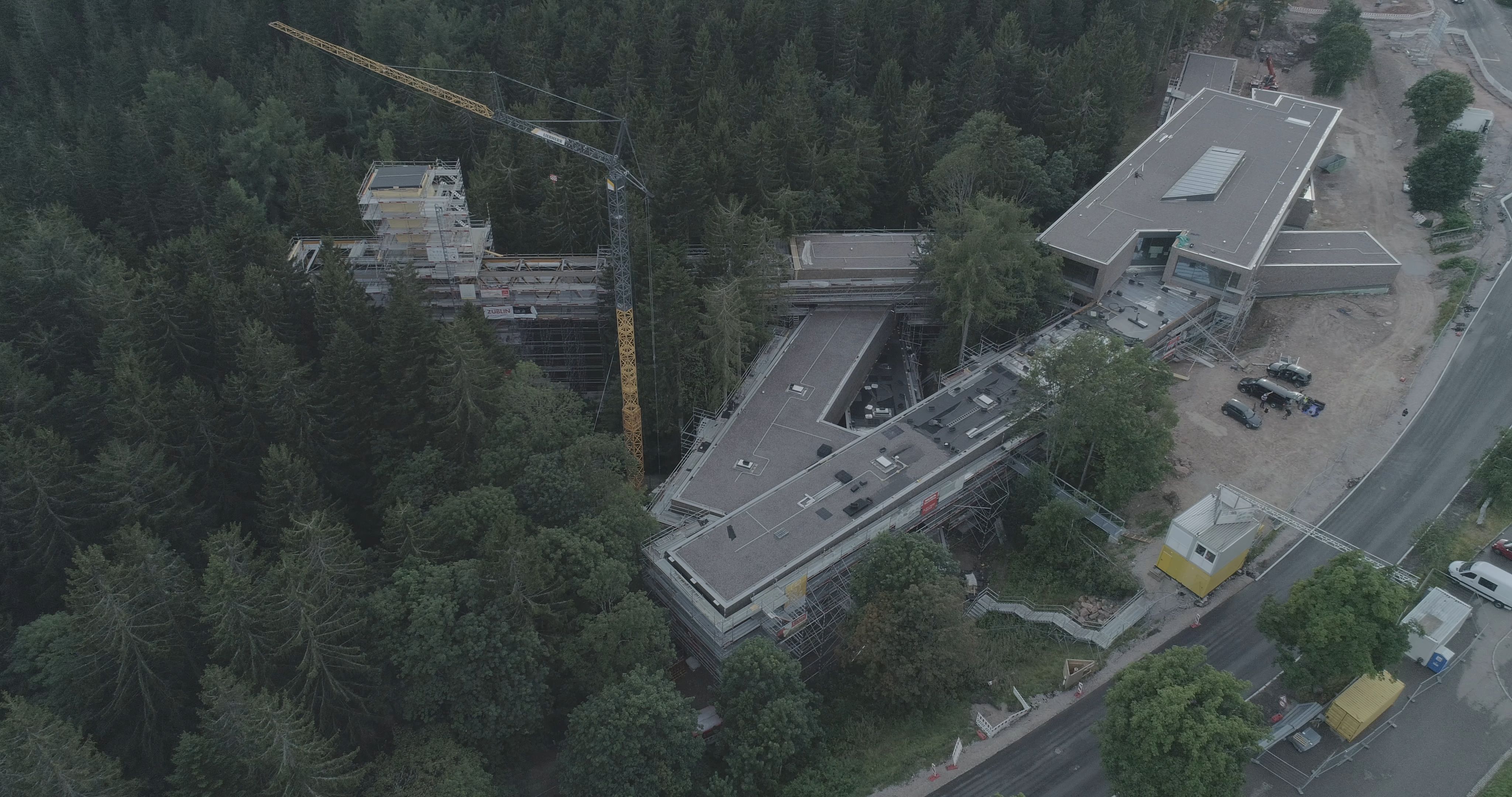Foto in der Vogelperspektive von einem Wald in dem sich eine Baustelle befindet. 