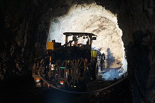 Foto zeigt einen Bagger in einer Tunnelröhre bei der Arbeit