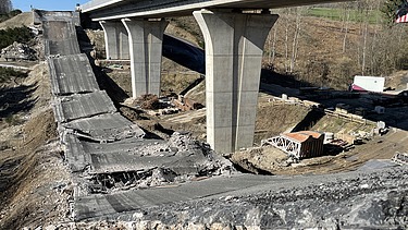Foton von einer gesprengten Brücke, die Bruchteile liegen auf der Erde, daneben steht noch die zweite Brücke
