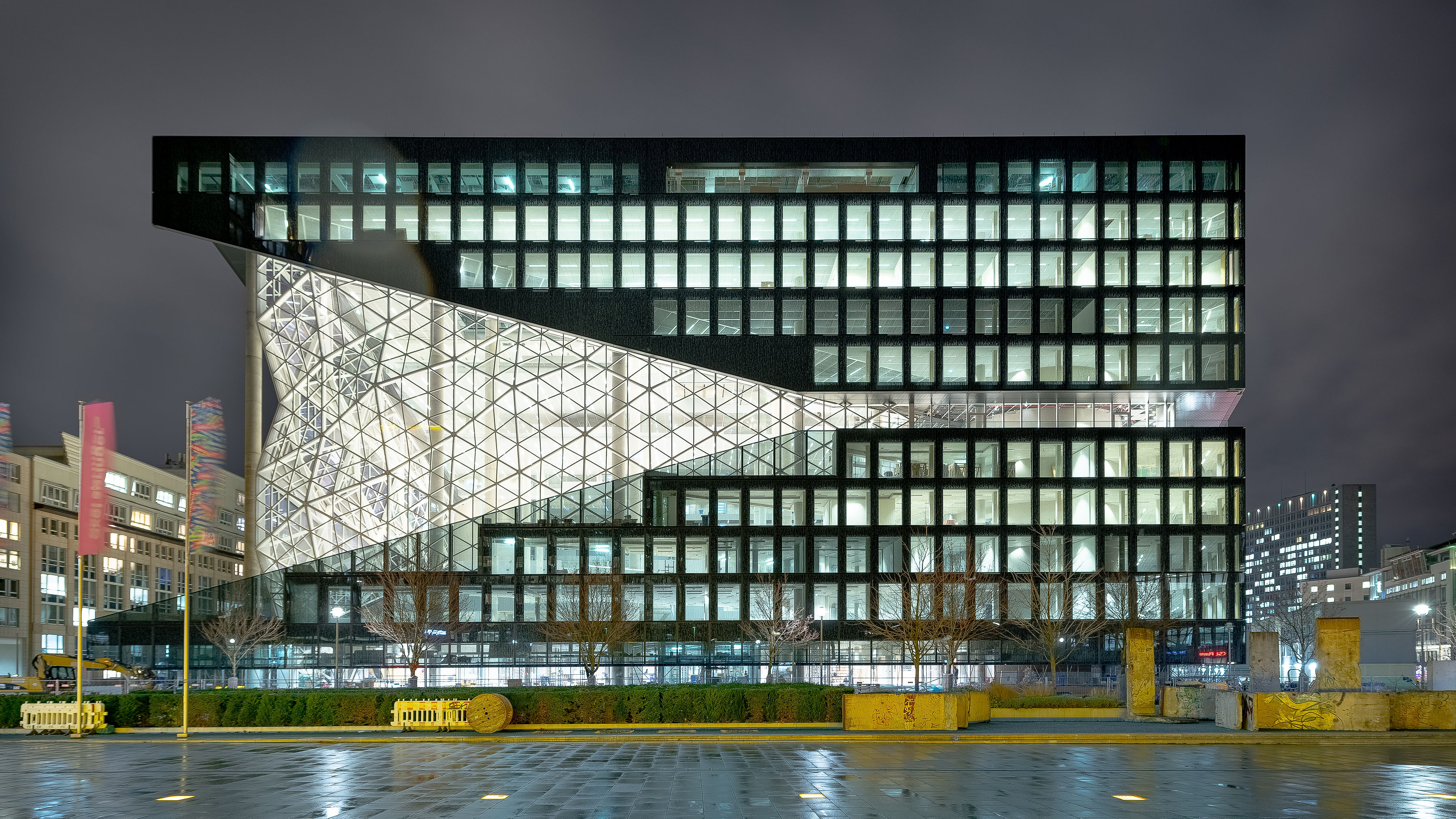 Foto von einem Bürogebäude von außen bei Nacht.  