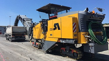 Foto einer SAT Asphaltfräse im Einsatz bei blauem Himmel