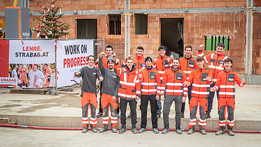 Foto von zwölf STRABAG Lehrlingen, die ein Haus errichteten