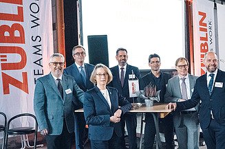 Foto von mehreren glücklich schauenden Personen bei der Jubiläumsfeier am Standort Sande.