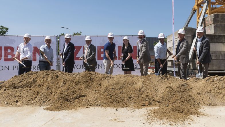 Photo of several people in suits at the laying of the foundation stone.