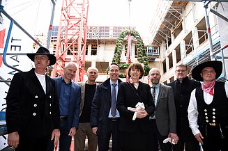 Foto mit der Oberbürgermeisterin von Köln auf der Baustelle im Antoniter Quartier in Köln. Um sie herum sind glück schauende Männer. 