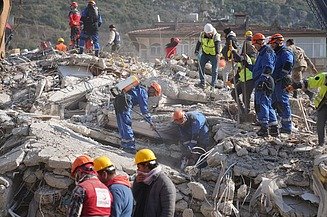 The picture shows relief workers at an earthquake site with rubble