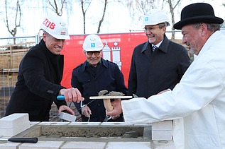Foto von vier Männern bei der Grundsteinlegung für die Erweiterungsbau der Techniker Krankenkasse in Hamburg.