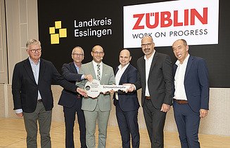 Handover of the keys to the Esslingen District Office The picture 6 people in a row holding a large key