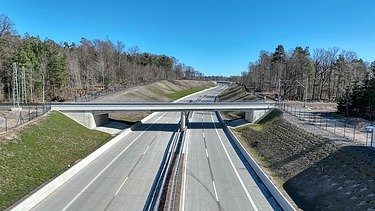 Bahnbrücke, die über eine Autobahn führt