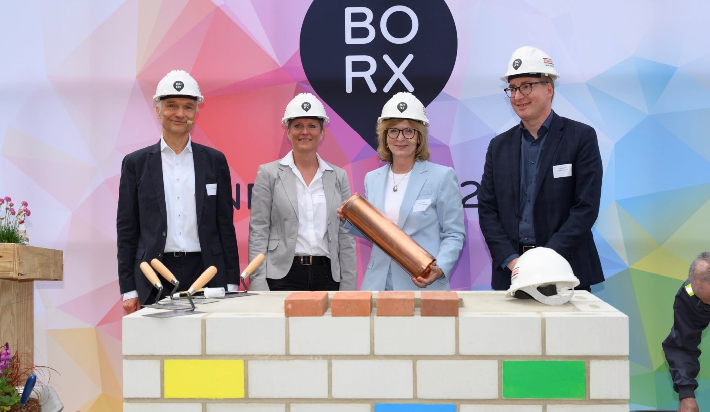 Foto von mehreren Personen die schick gekleidet, sind bei der symbolische Grundsteinlegung für Bürogebäude BORX.