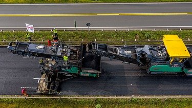 Foto zweier Asphaltbaumaschinen von oben gesehen