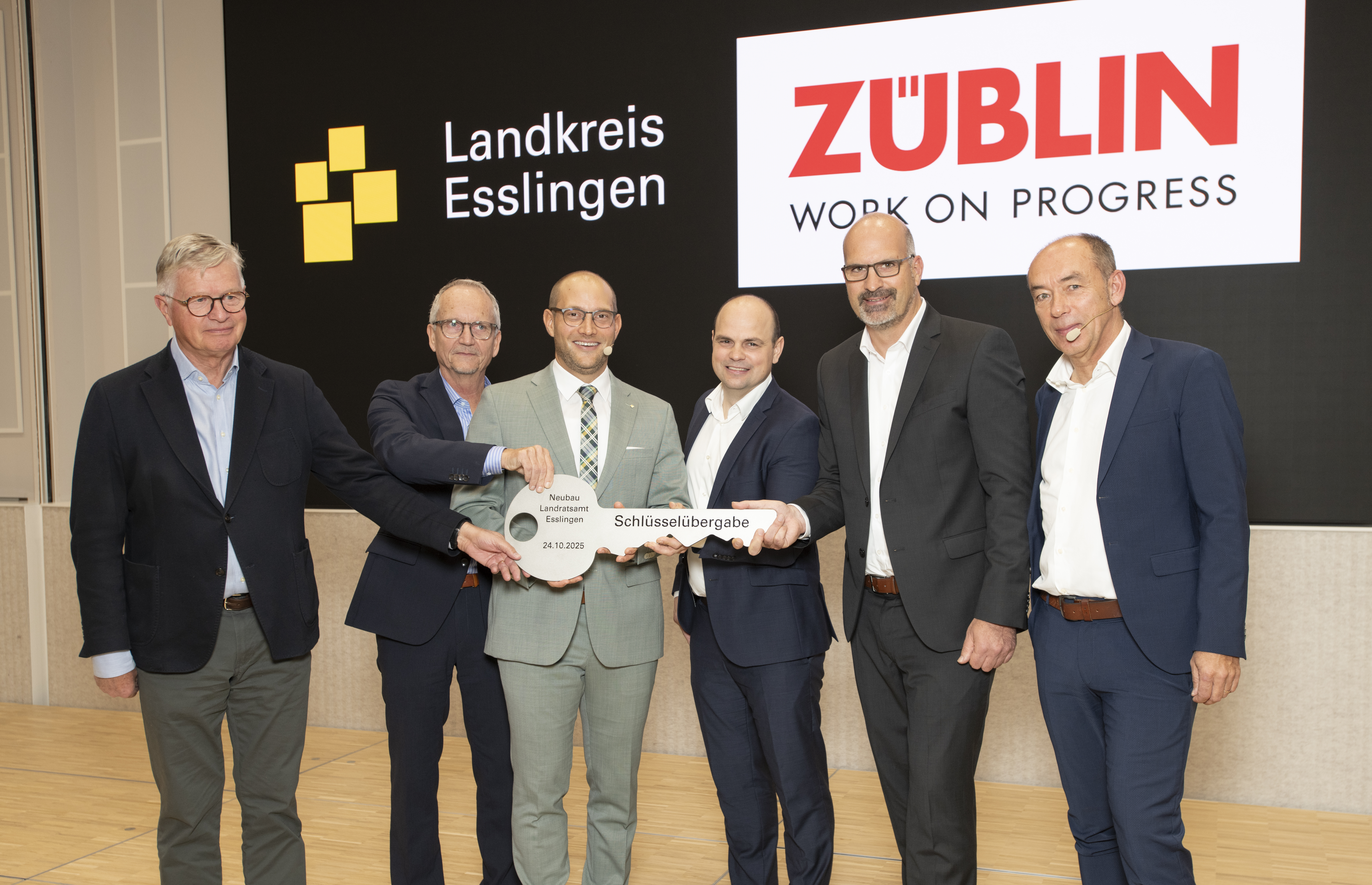 The picture 6 people in a row holding a large key