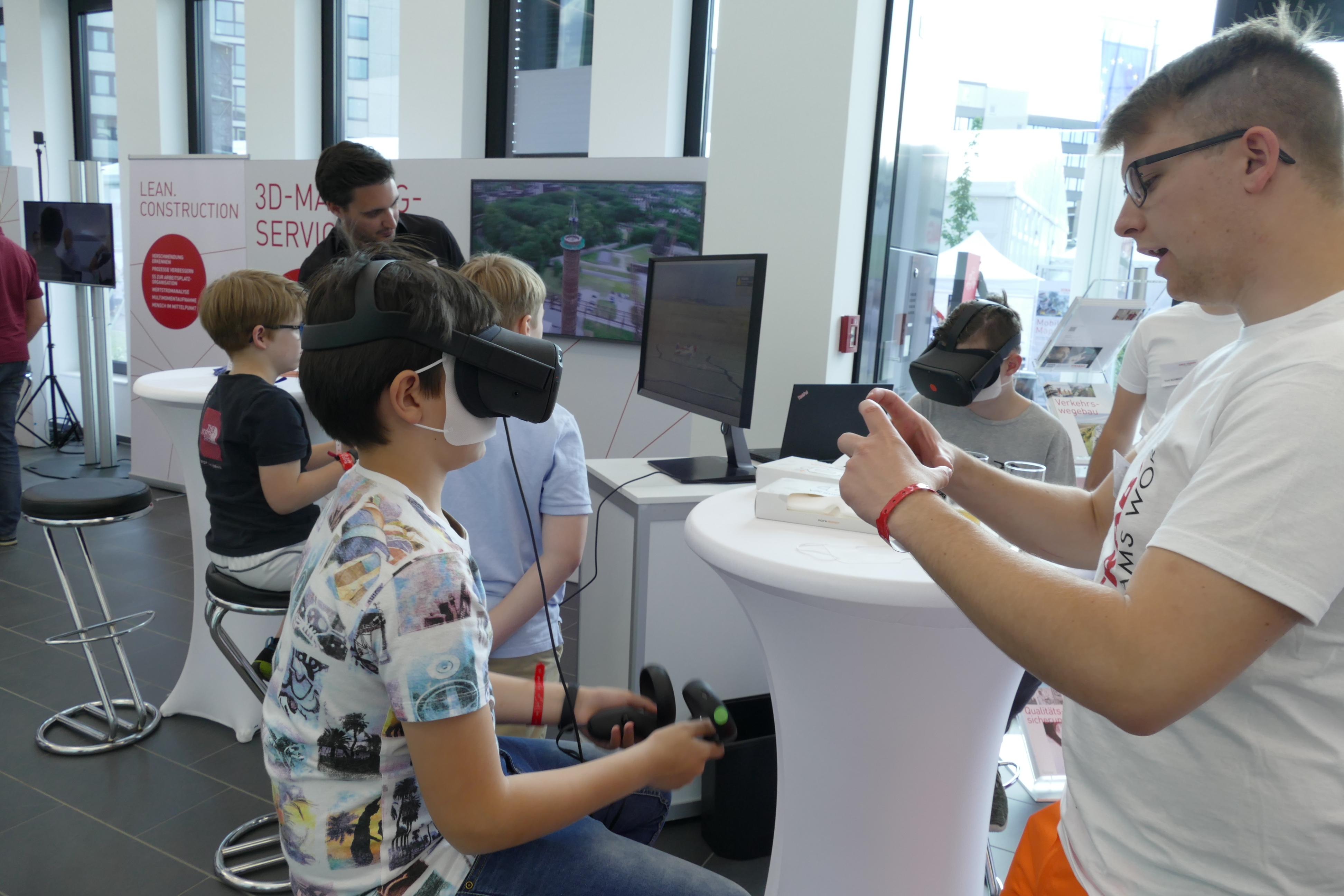 Foto von Kindern die mit Starbag Mitarbeitern VR-Brillen testen. 