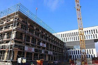 Foto vom Bau eines Hauses. An der Seite ist ein Karan zusehen. 