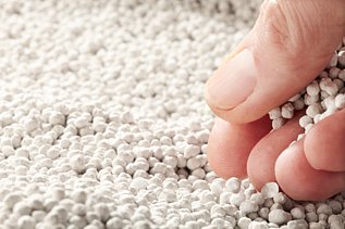 Photo of Polyhalite fertilizer and a hand