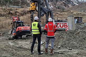 Zwei Personen schauen auf eine Baustelle