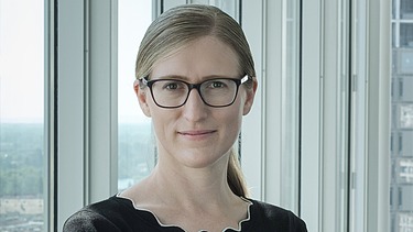 Foto von Marianne Jakl, die vor einem Fenster steht