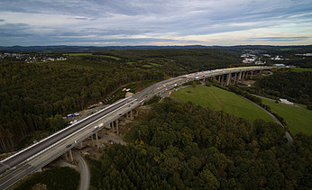 Das Bild zeigt eine Talbrücke durch ein Waldgebiet