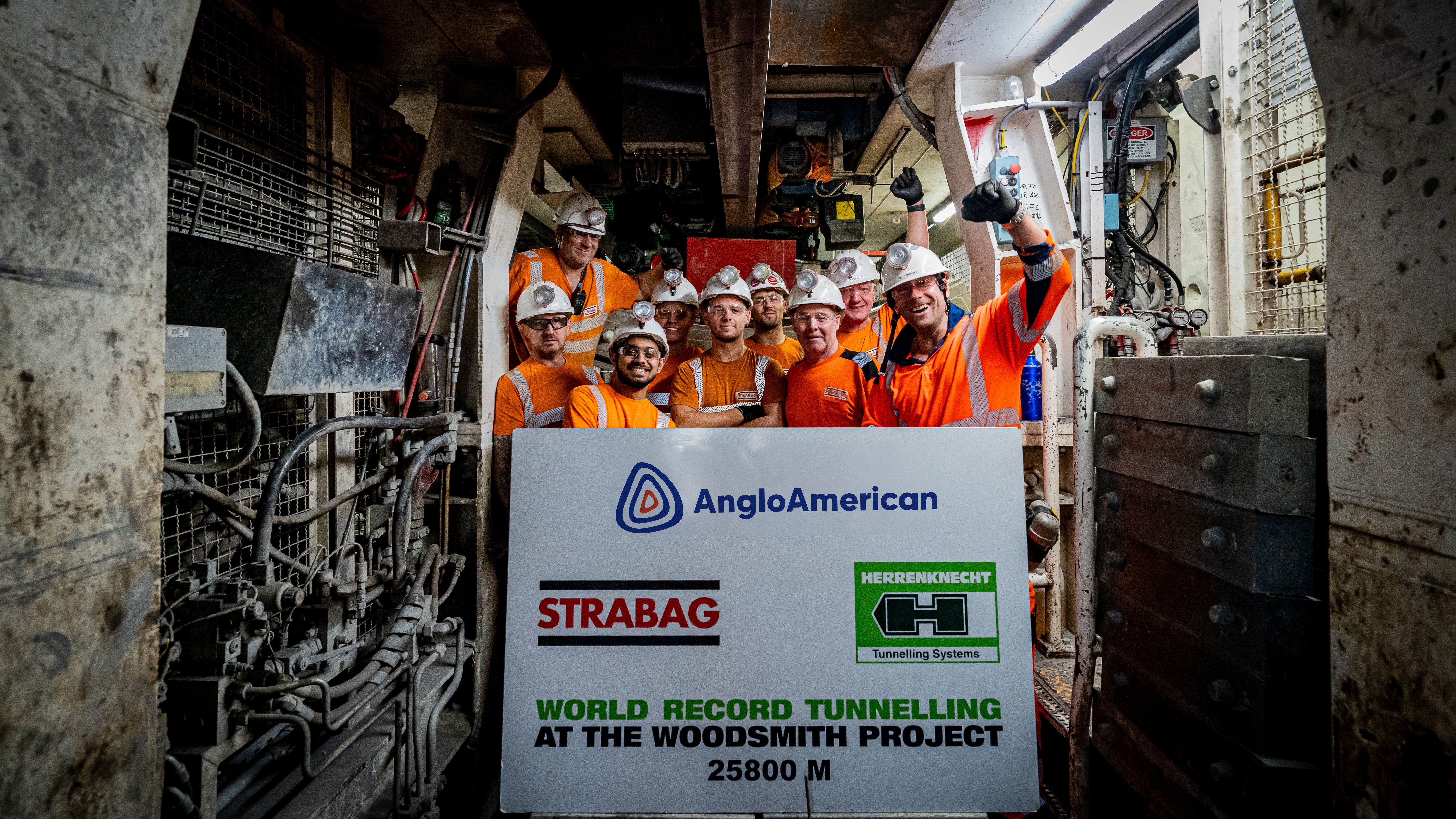 Photo of several people celebrating a tunnel breakthrough and holding a large board in their hands