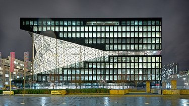 Foto von einem Bürogebäude von außen bei Nacht.  