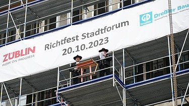 Foto von einer Rede auf einem Gerüst. 