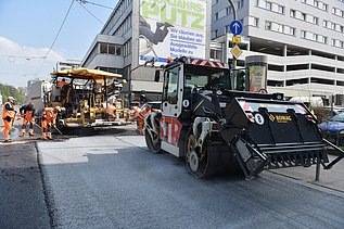 Foto von zwei Straßenbaumaschinen auf einer neuen Straße