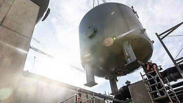 Foto von einem schweren Kessel, der in die Höhe gehoben wird mit einem Kran
