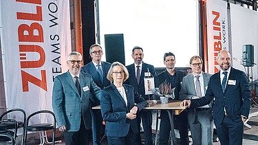 Foto von mehreren glücklich schauenden Personen bei der Jubiläumsfeier am Standort Sande.