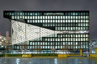Foto von einem Bürogebäude von außen bei Nacht.  