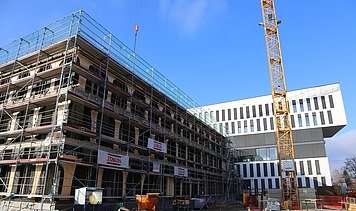 Foto vom Bau eines Hauses. An der Seite ist ein Karan zusehen. 