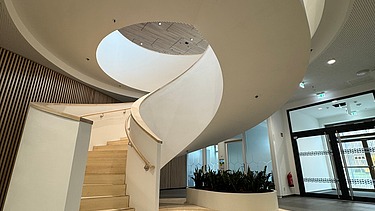 Bild von einer weißen Betonwendeltreppe im Innenraum