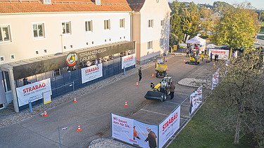 Foto von eines Gebäudes mit einem Parkplatz umgeben von Bauzäunen