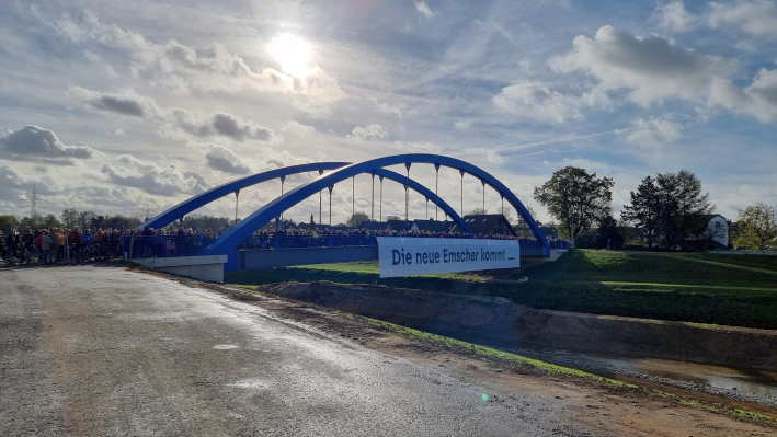 Foto von einer Brücke über einen Fluss, der Himmel ist leicht bewölkt