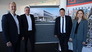 Foto von vier Personen die freundlich schauen. 