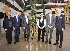 Foto von freundlich schauenden Personen vor dem Richtkranz.